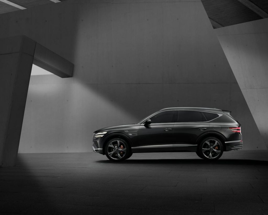 Elegant black SUV parked in a contemporary concrete structure, showcasing modern design elements.