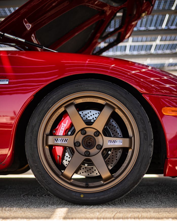 close-up-of-red-car-with-bronze-wheel-and-open-hood-32293562