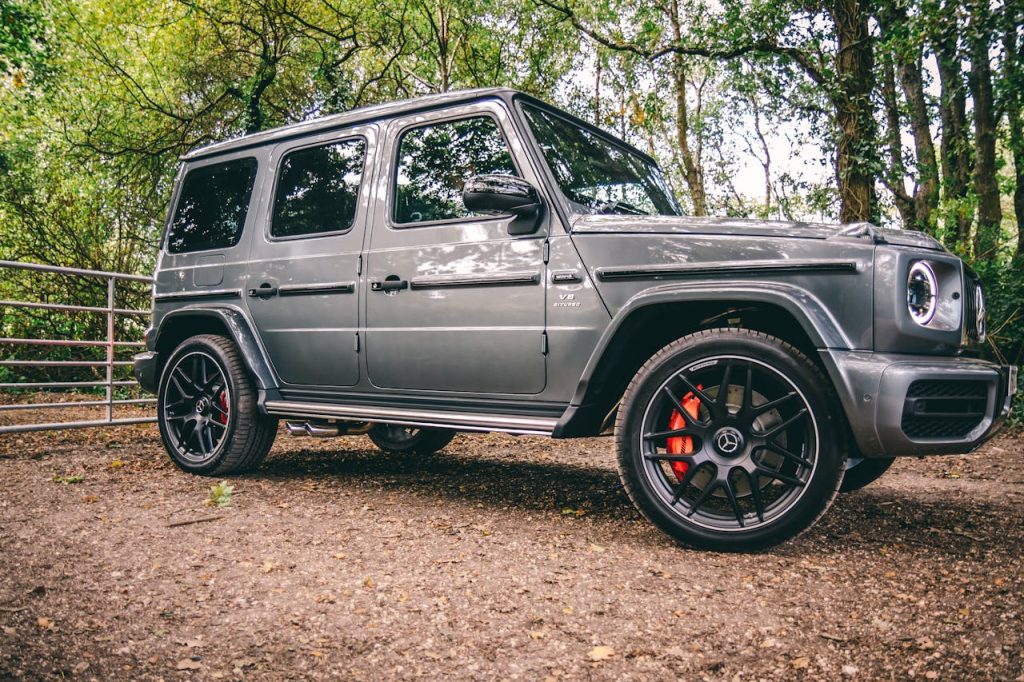 A luxurious Mercedes-Benz SUV parked in a scenic wooded area, showcasing elegance and power.